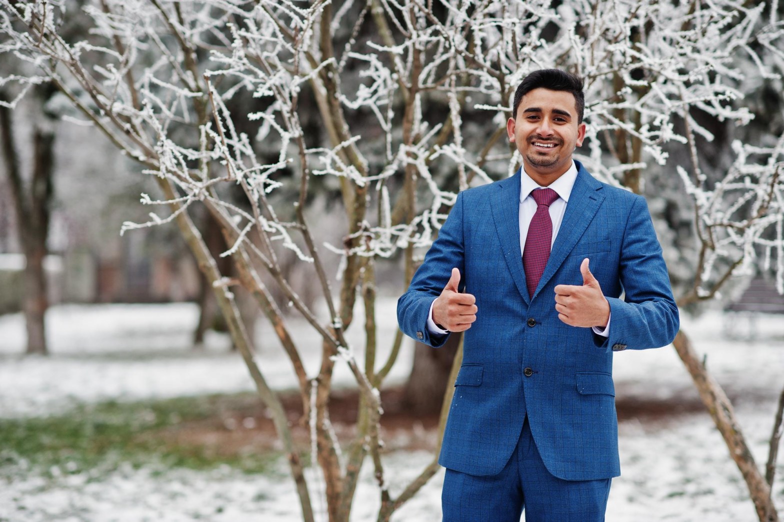 man in blue suit smiling with snowy trees in the background   dr krishna athal